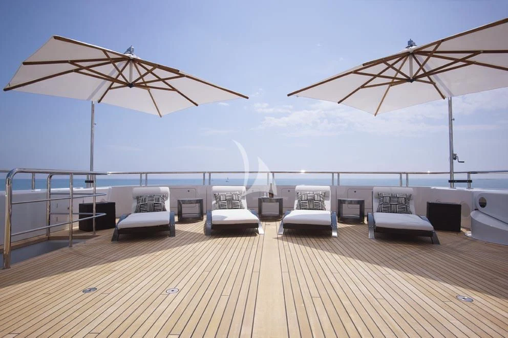 a deck with lounge chairs and umbrellas on it aboard HURRICANE RUN Yacht for Charter