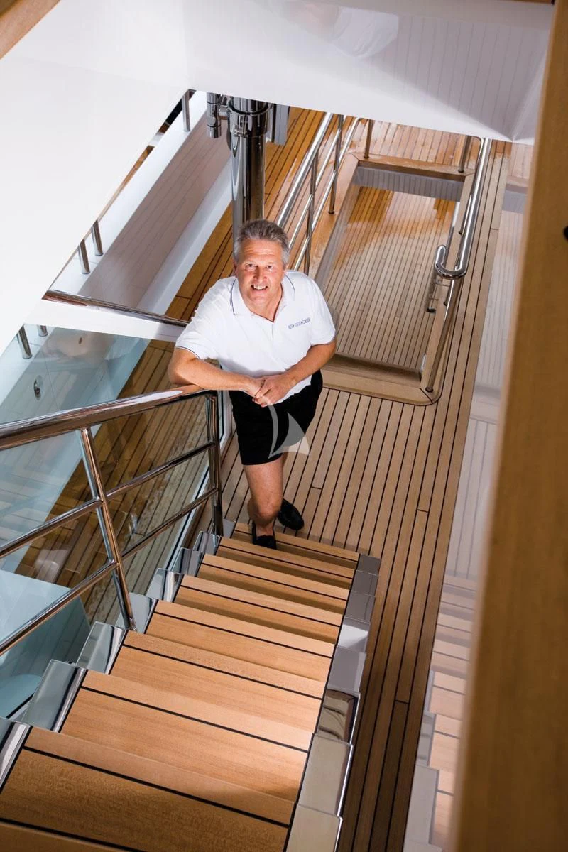 a man sitting on a staircase aboard HURRICANE RUN Yacht for Charter