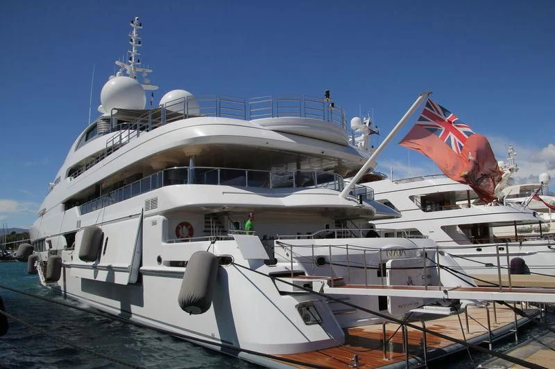 a large white boat with a flag on the front aboard NAIA Yacht for Sale