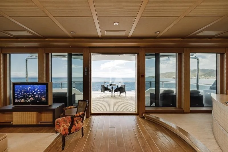 a room with a large window and a wood floor aboard NAIA Yacht for Sale