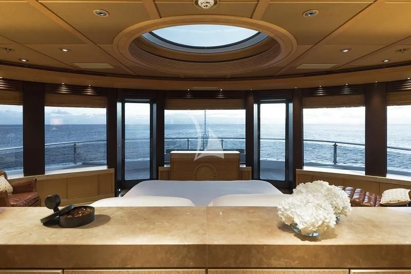 a room with a large window and a large white flower on the ceiling aboard NAIA Yacht for Sale