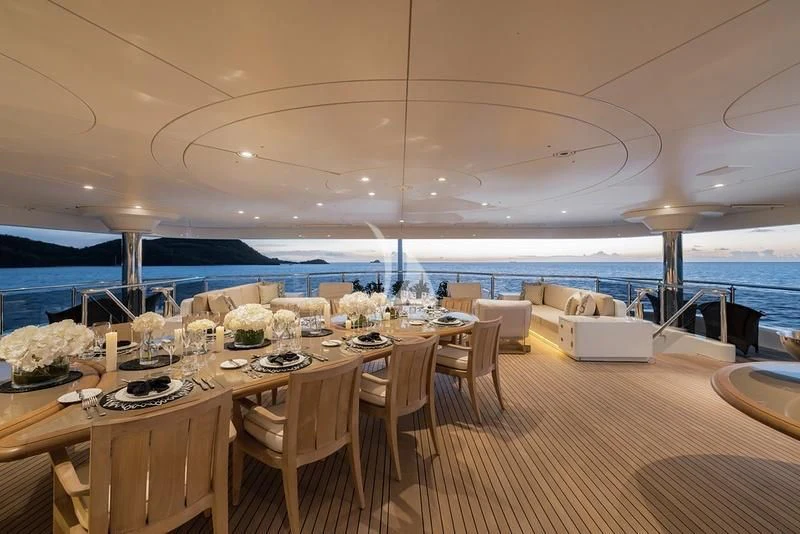 a room with tables and chairs aboard NAIA Yacht for Sale