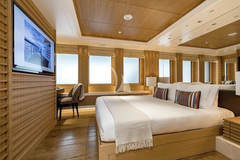 a room with a bed and a tv on the wall aboard NAIA Yacht for Sale