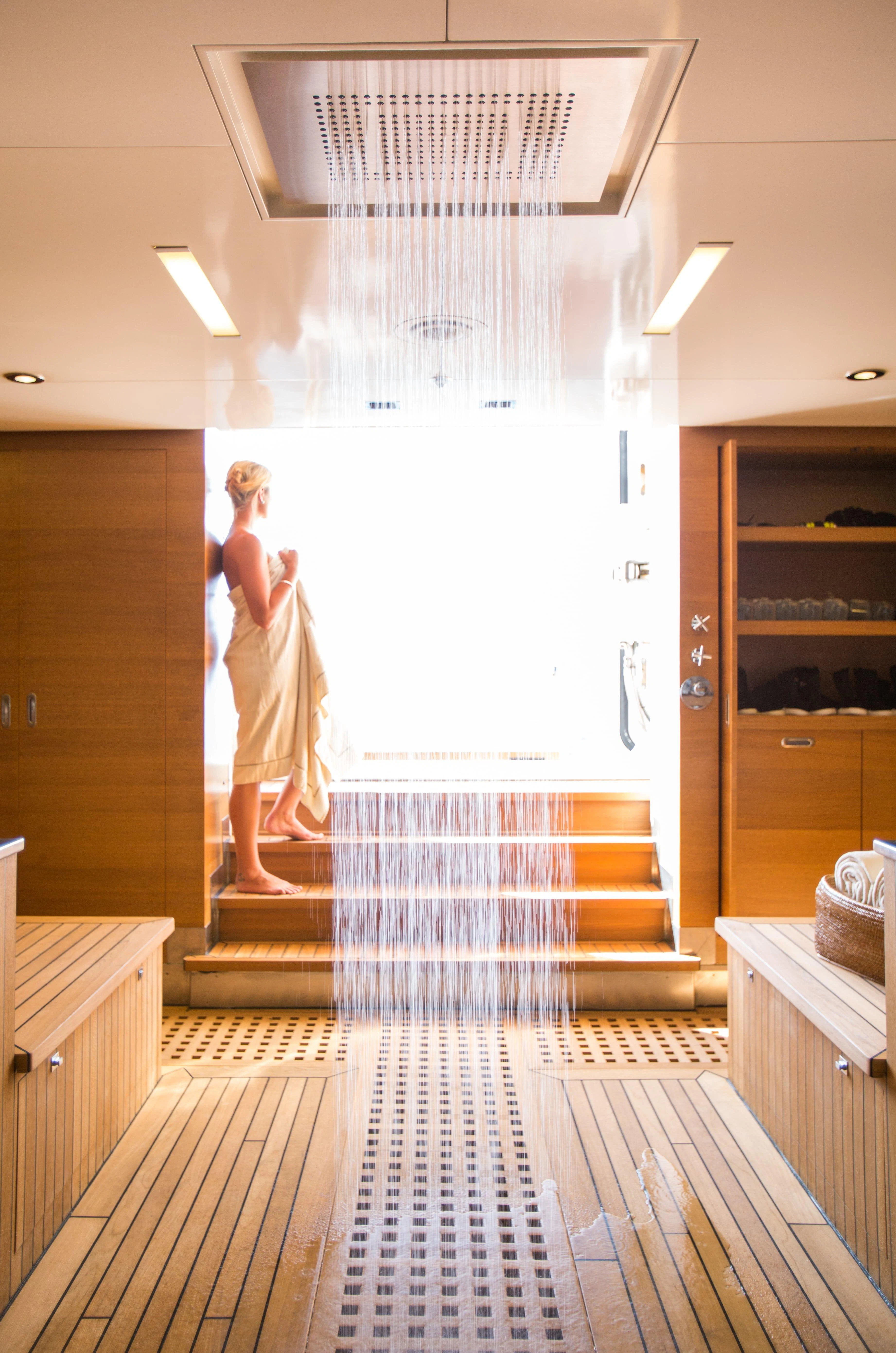a person in a white dress in a bathroom aboard NAIA Yacht for Sale