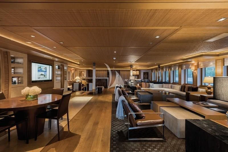 a living room with a wood table aboard NAIA Yacht for Sale