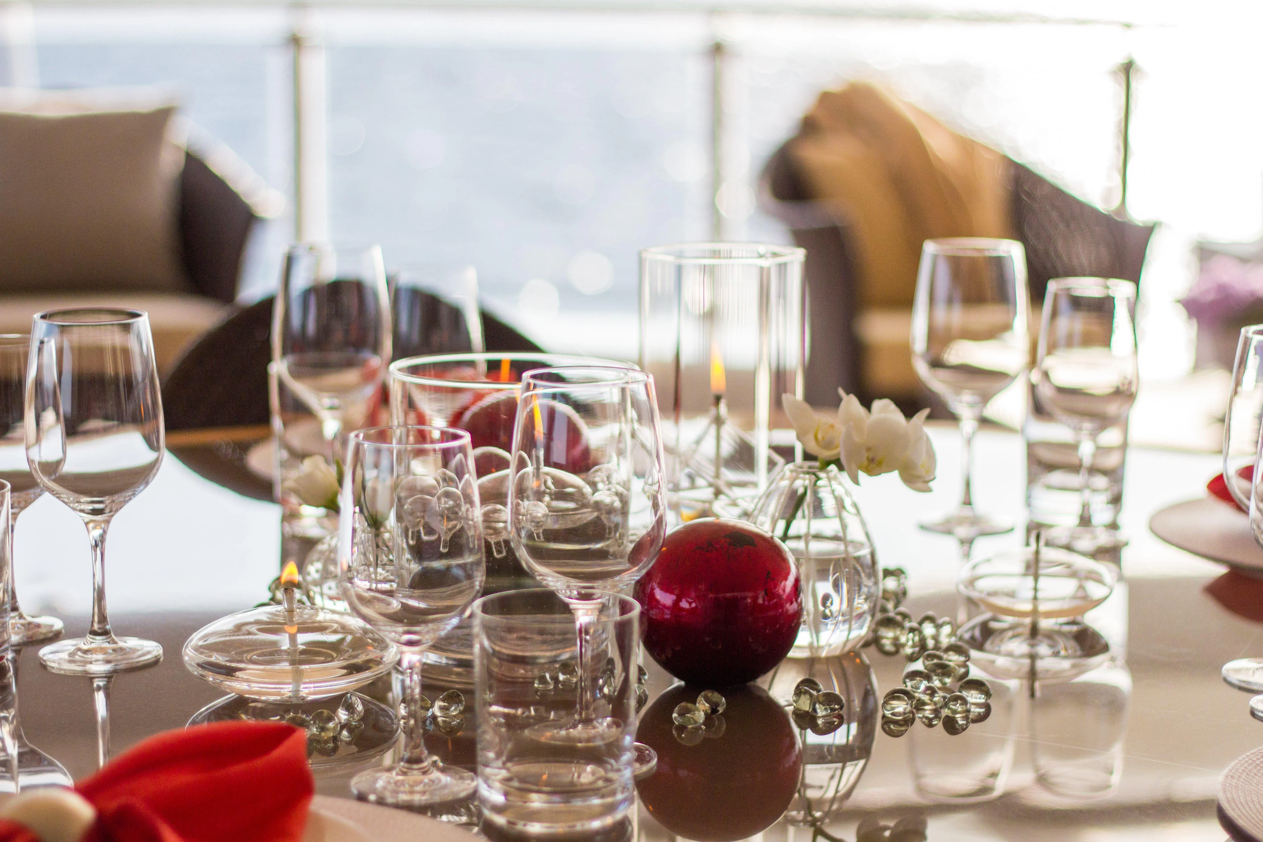 a table with wine glasses and flowers aboard NAIA Yacht for Sale