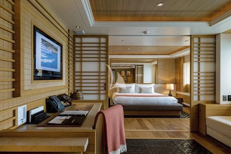a bedroom with a bed and desk aboard NAIA Yacht for Sale