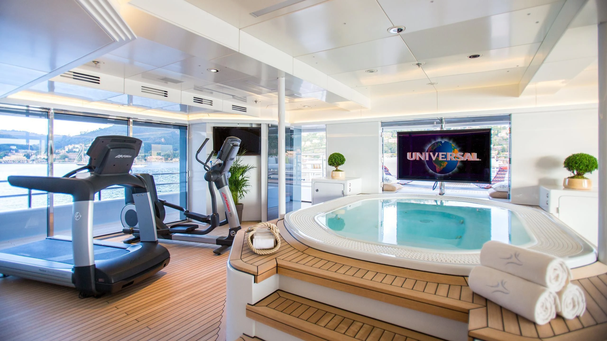 a room with a pool table and chairs and a large window aboard NAIA Yacht for Sale