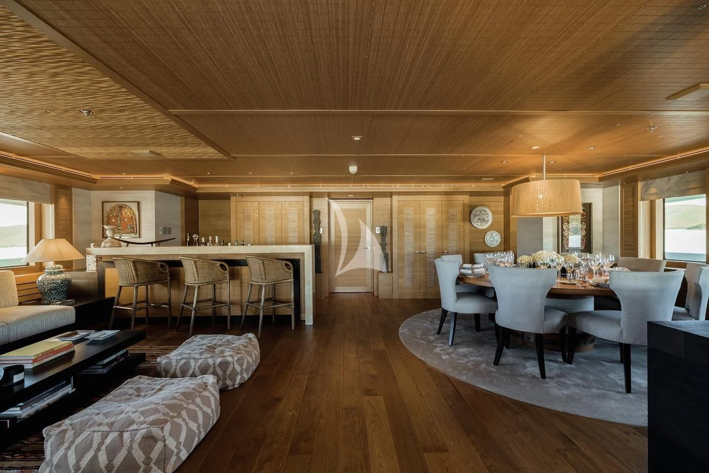 a large living room with a wood floor aboard NAIA Yacht for Sale