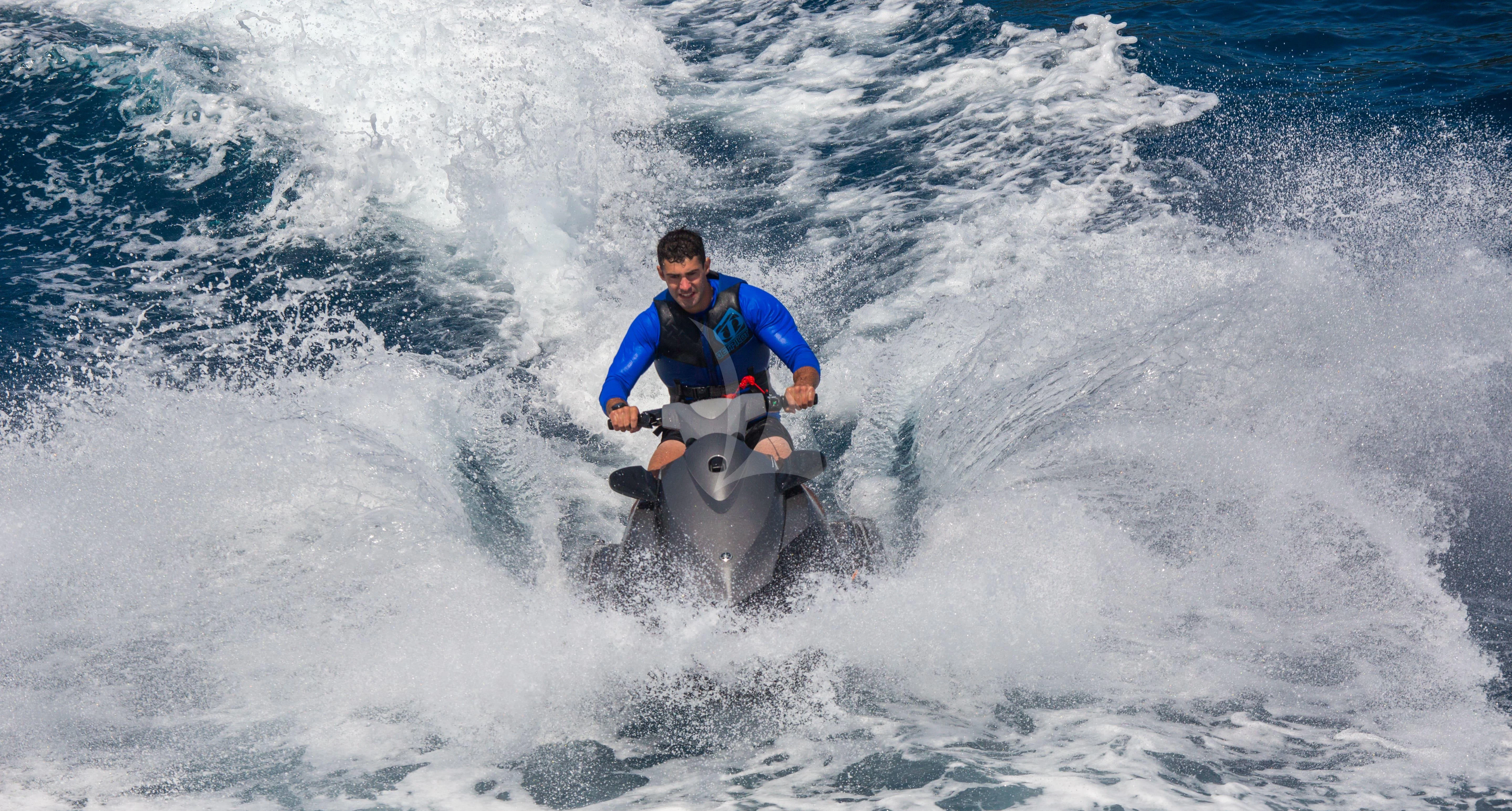 a man riding a jet ski aboard NAIA Yacht for Sale