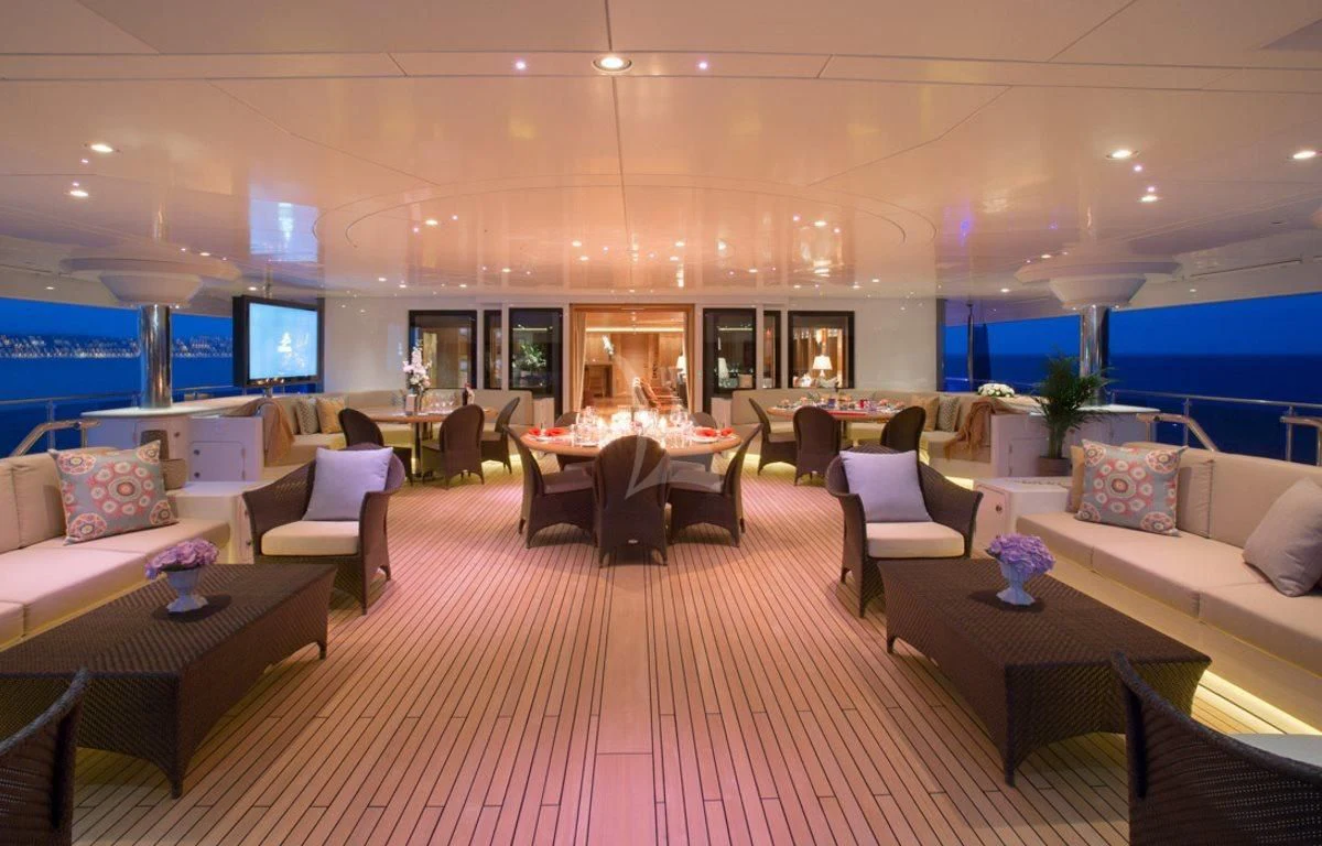 a large room with a table and chairs aboard NAIA Yacht for Sale