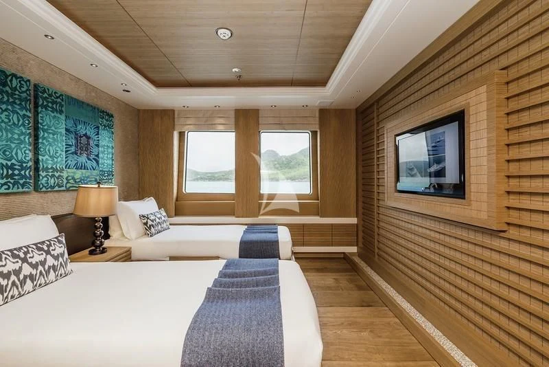 a room with a bed and a tv on the wall aboard NAIA Yacht for Sale