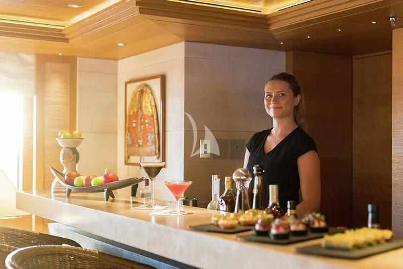 a woman standing behind a counter aboard NAIA Yacht for Sale
