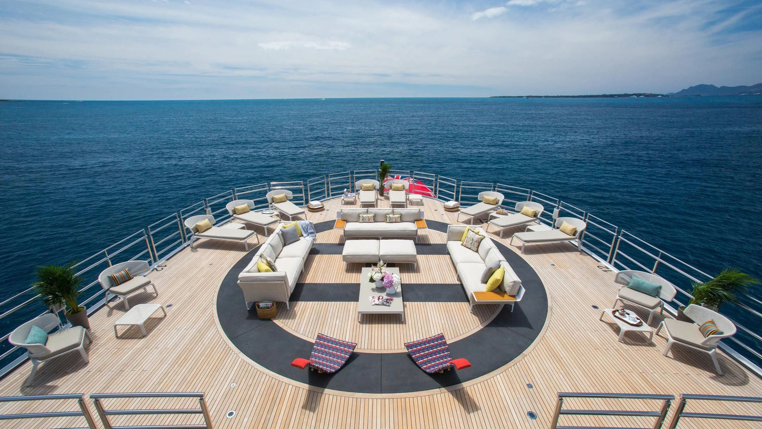 a deck with chairs and tables on it by the water aboard NAIA Yacht for Sale