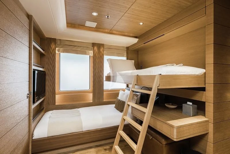 a wooden bunk bed in a room aboard NAIA Yacht for Sale