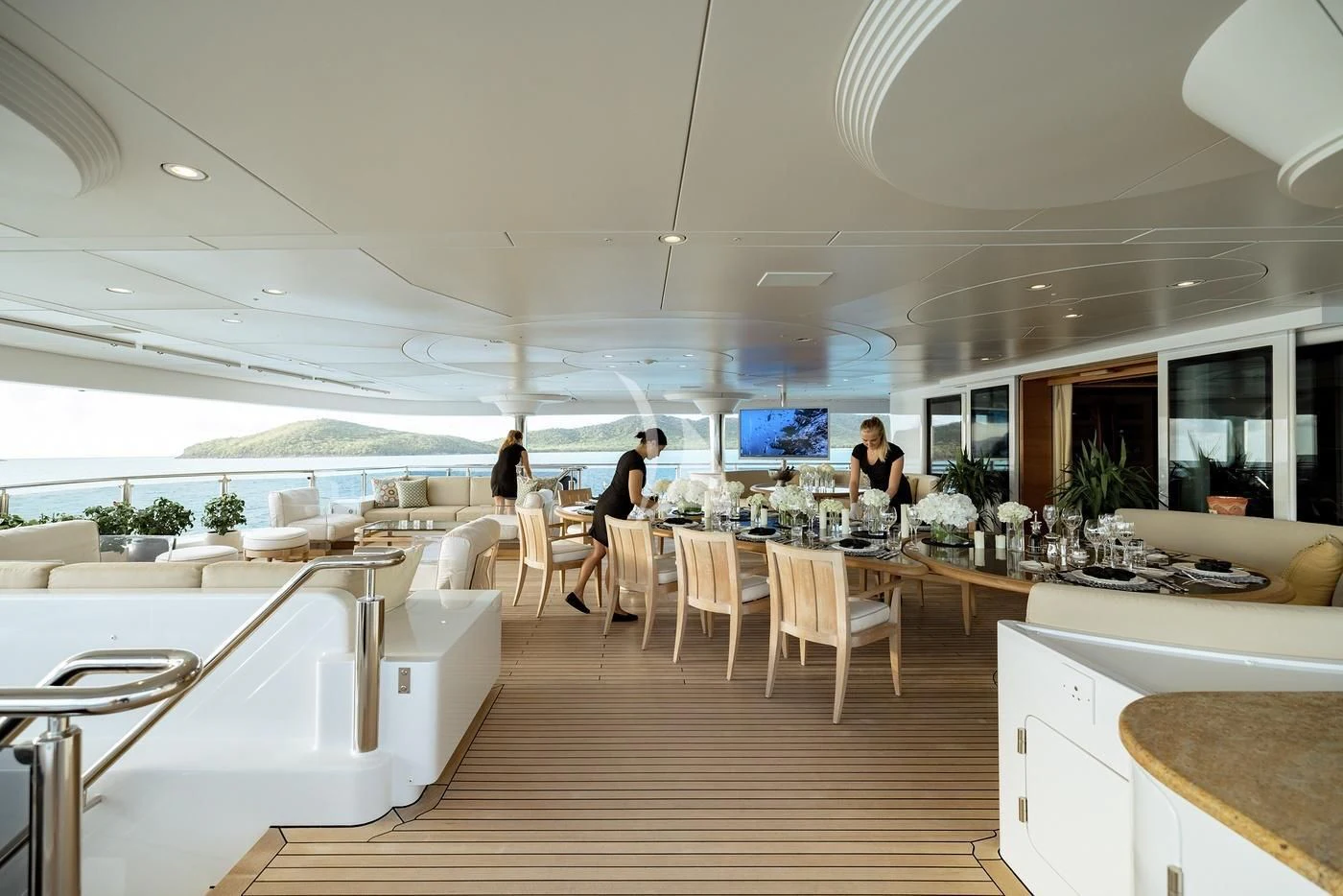 a room with tables and chairs aboard NAIA Yacht for Sale