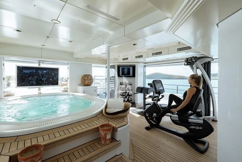 a person sitting in a chair in a room with a large window aboard NAIA Yacht for Sale