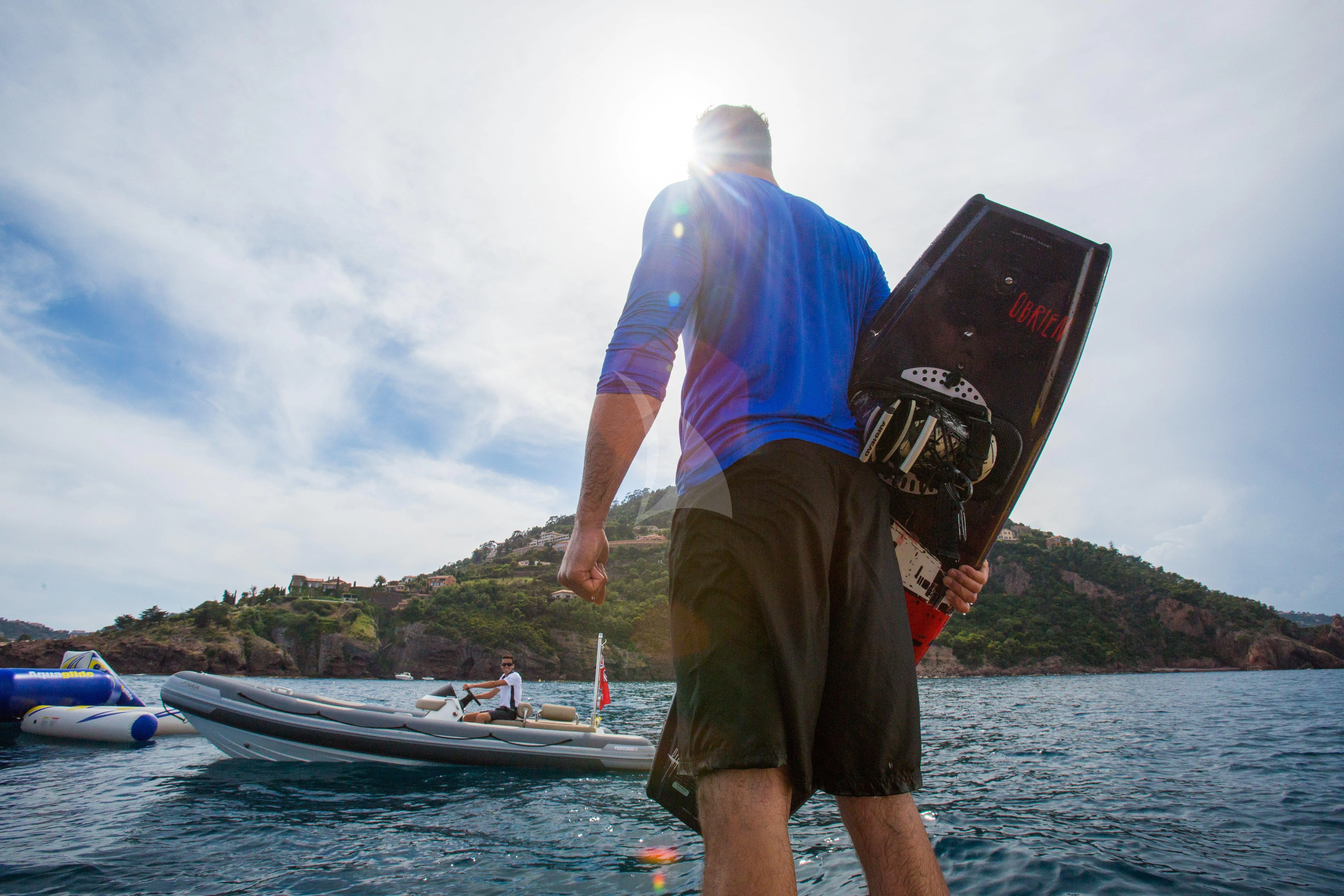 a man holding a hat and standing in water aboard NAIA Yacht for Sale