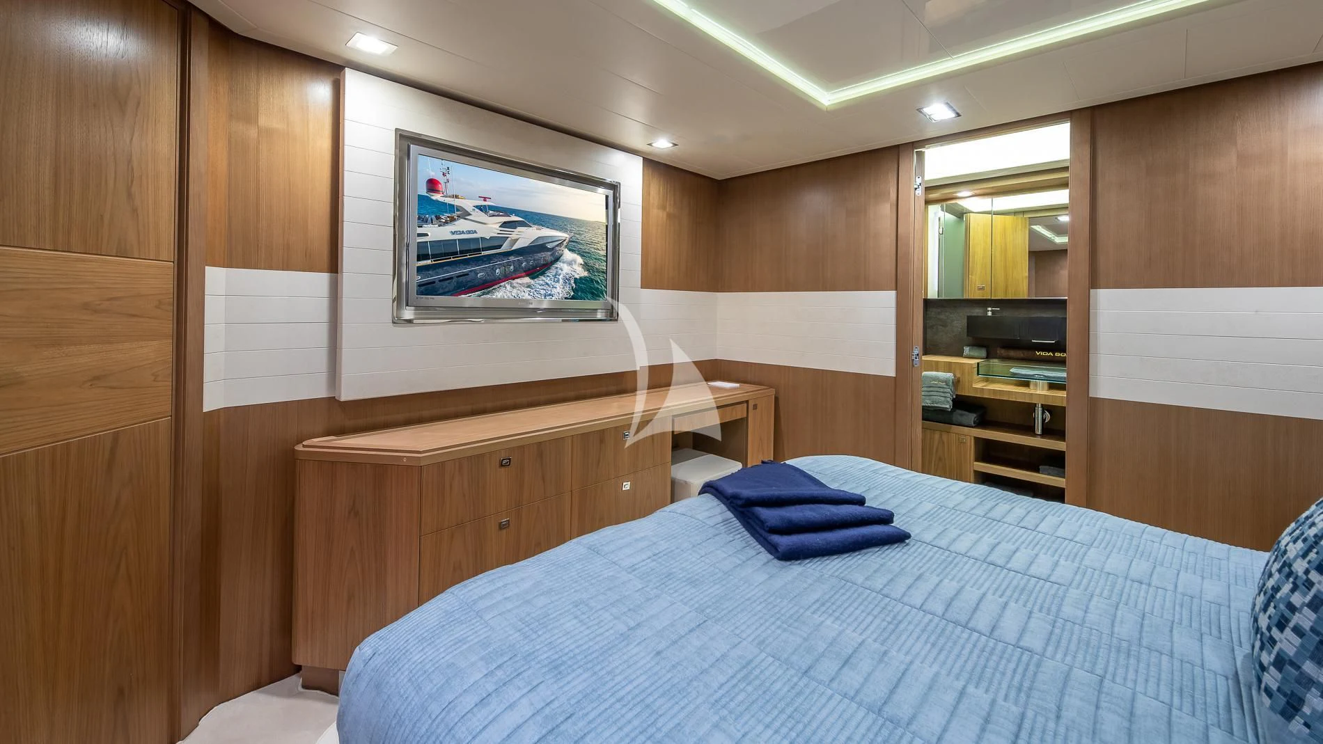 a room with a bed and a television aboard ONE AND ONLY Yacht for Sale