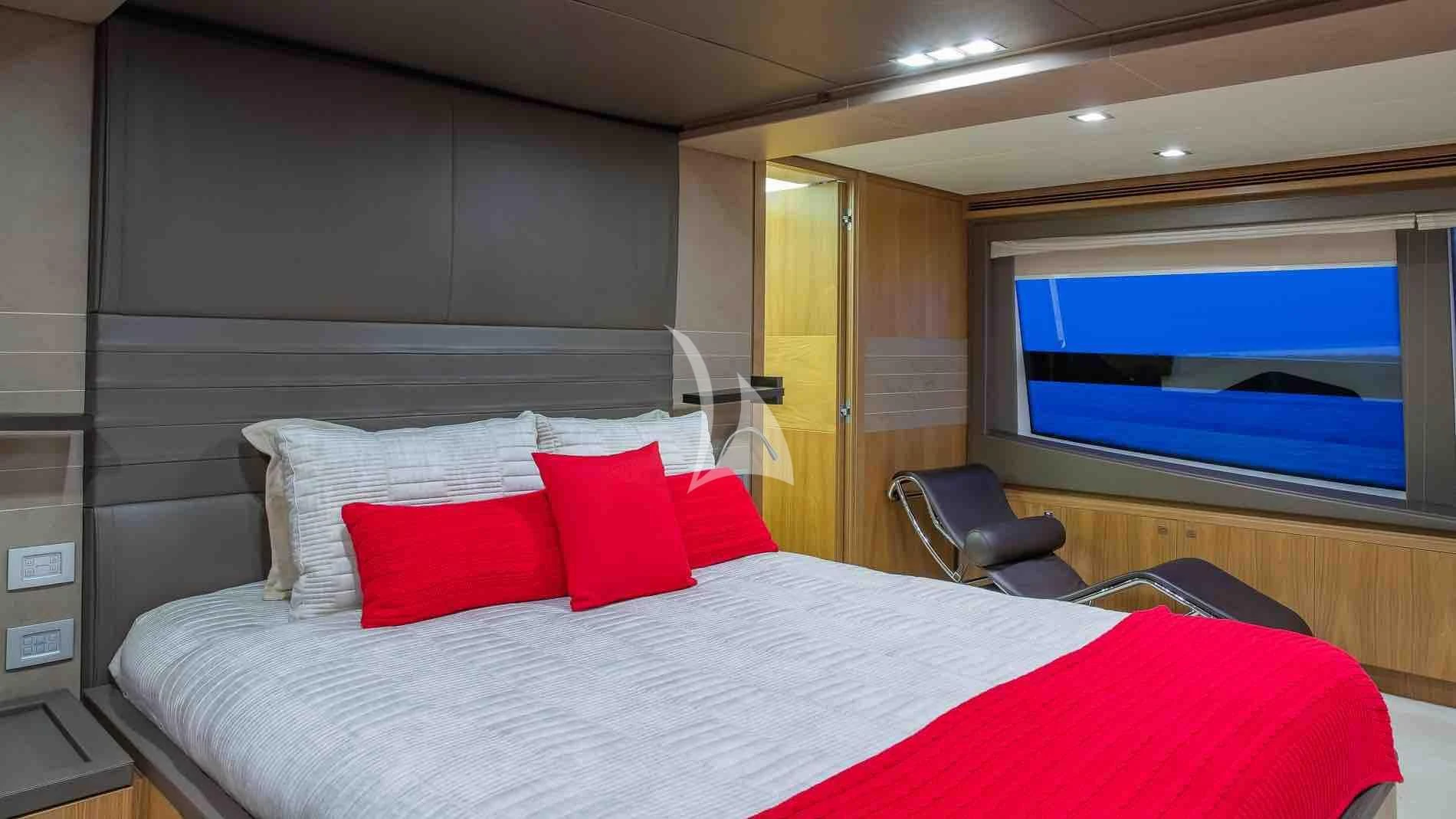 a bed with red pillows aboard ONE AND ONLY Yacht for Sale