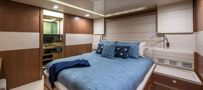a room with a bed and a mirror aboard ONE AND ONLY Yacht for Sale