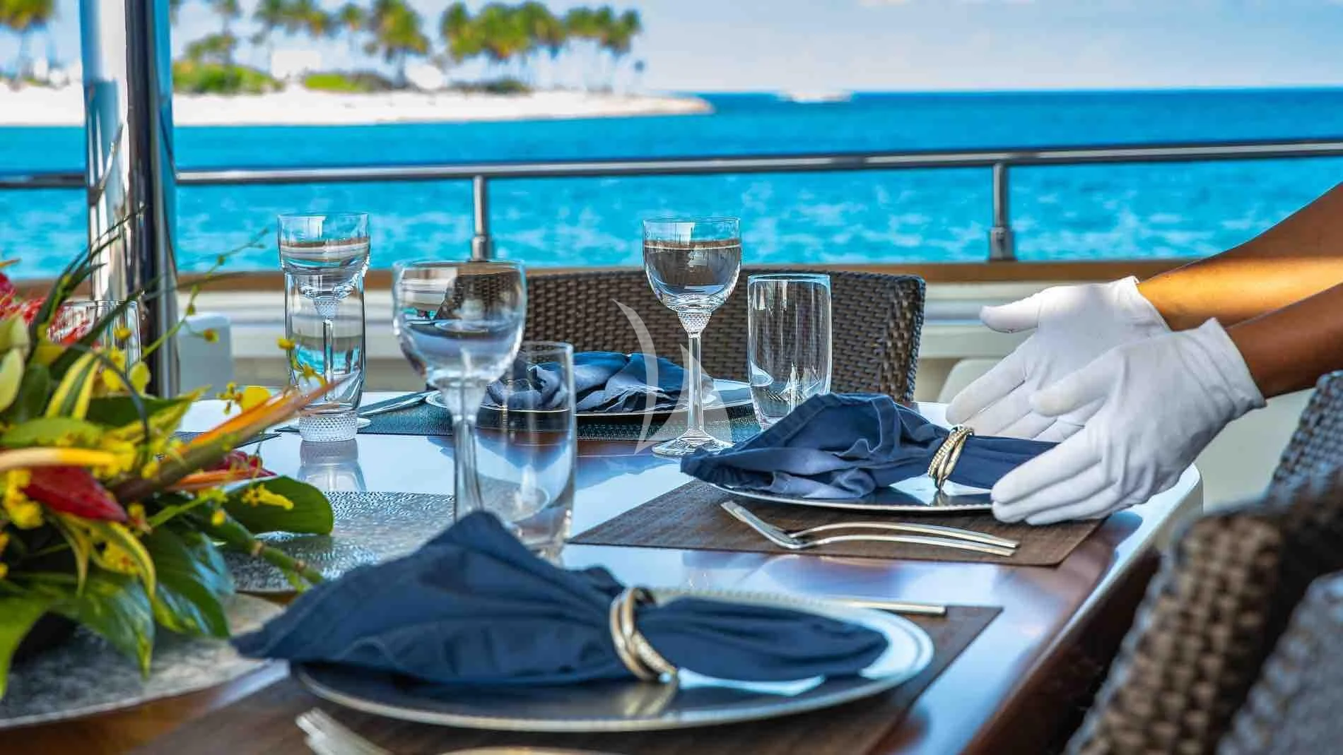 a table with plates and glasses aboard ONE AND ONLY Yacht for Sale