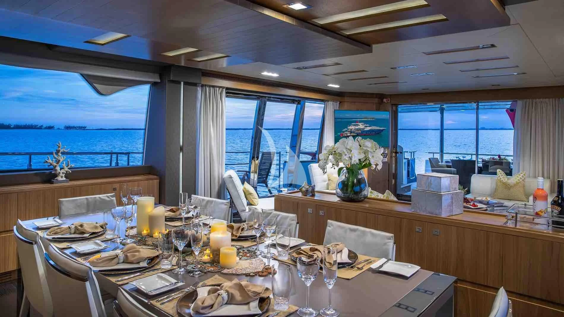 a large dining table with candles aboard ONE AND ONLY Yacht for Sale