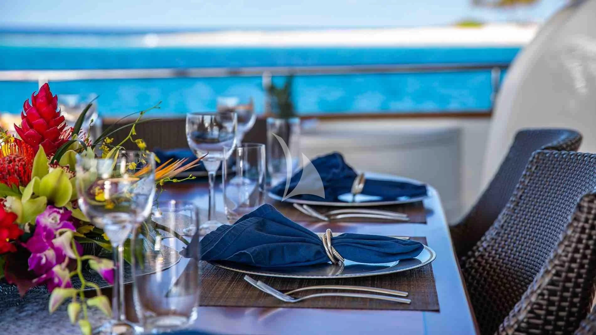 a table with a plate and glasses aboard ONE AND ONLY Yacht for Sale