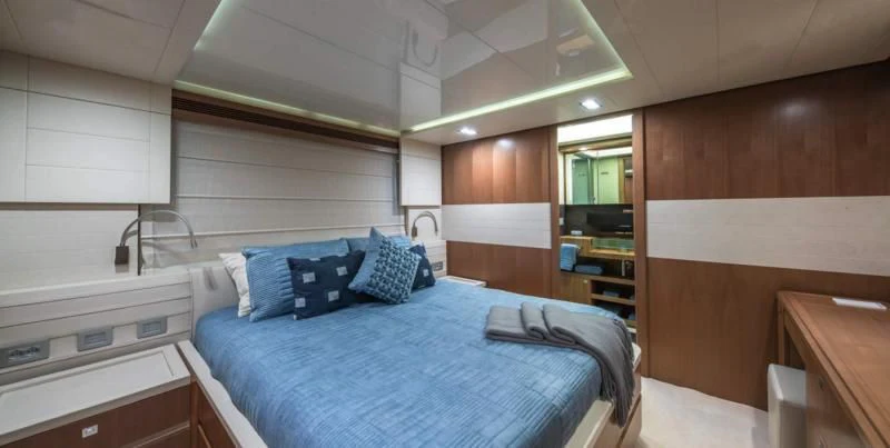 a room with a bed and a desk aboard ONE AND ONLY Yacht for Sale