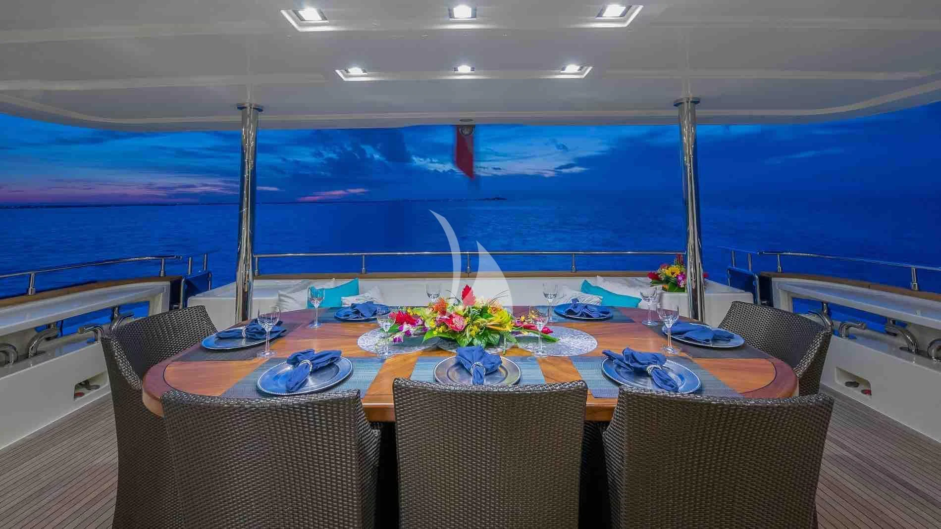 a table with chairs and a view of the ocean aboard ONE AND ONLY Yacht for Sale