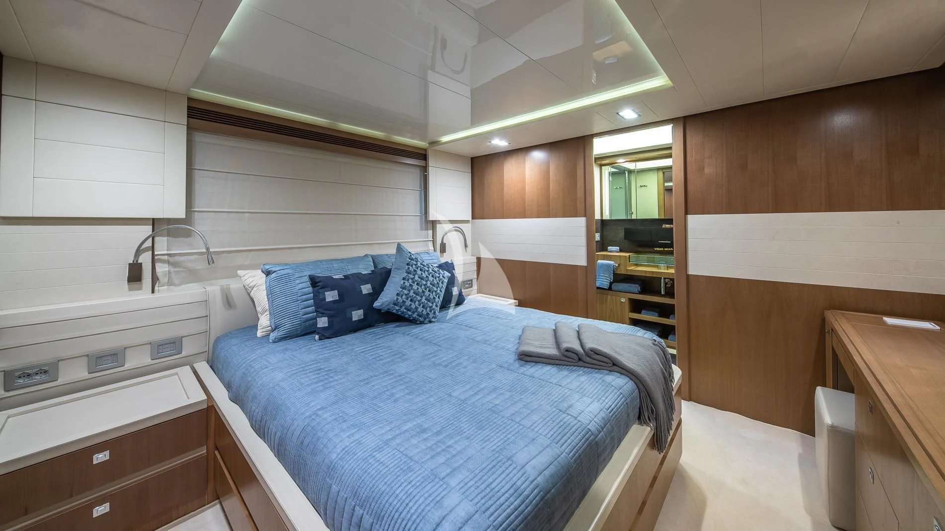 a room with a bed and a mirror aboard ONE AND ONLY Yacht for Sale