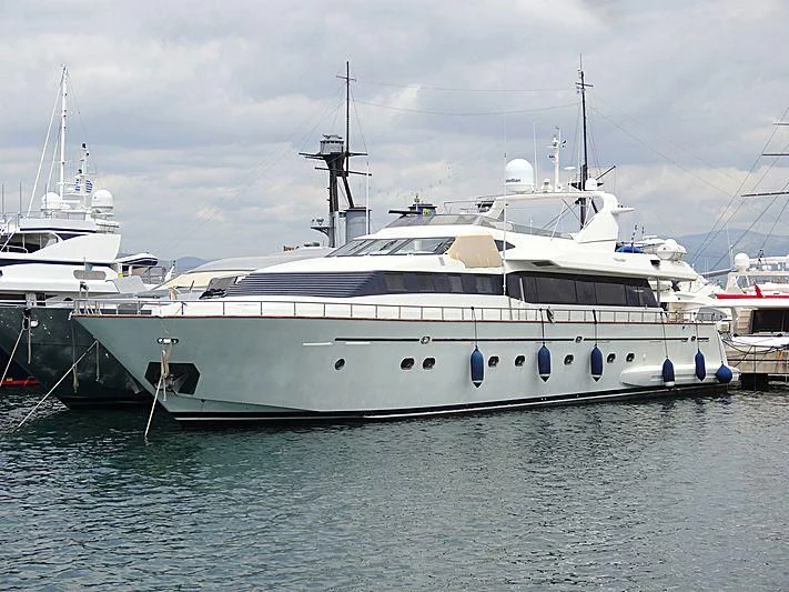 a large white boat in the water with USS Potomac (AG-25) in the background aboard FALCON ISLAND Yacht for Sale