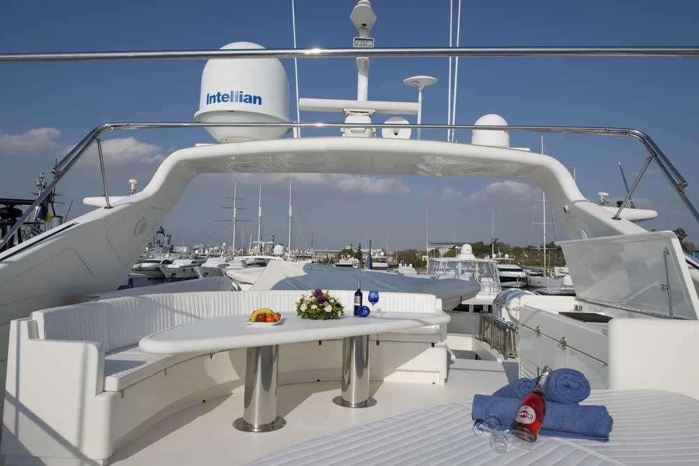 a white boat with a white table and a white table with a white table and chairs on it aboard FALCON ISLAND Yacht for Sale