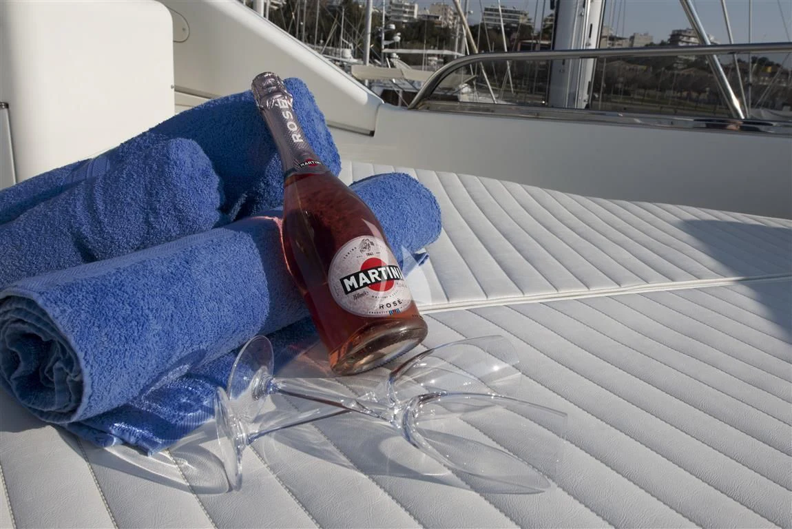 a bottle of alcohol on a bed aboard FALCON ISLAND Yacht for Sale