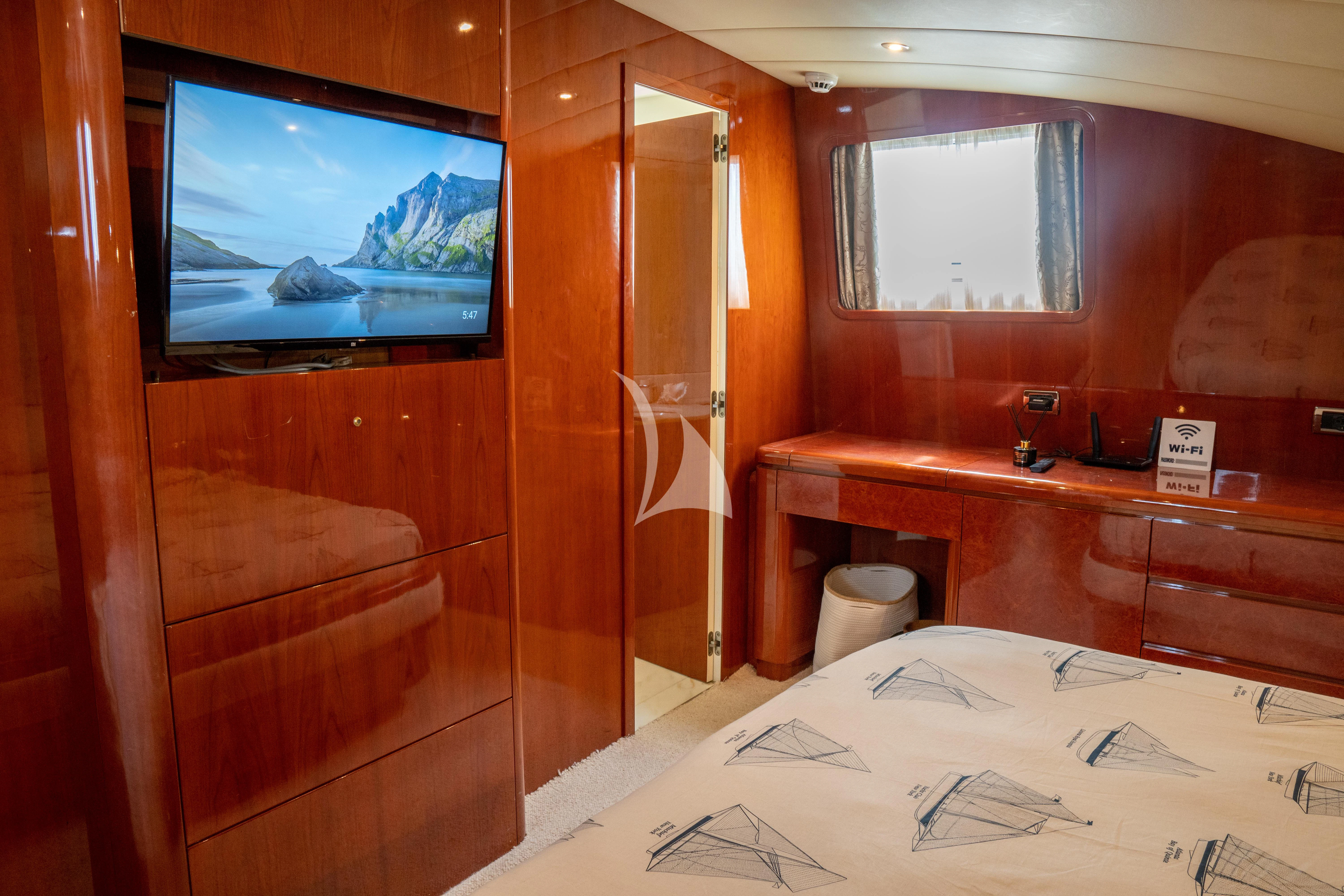 a room with a bed and a tv on the wall aboard FALCON ISLAND Yacht for Sale