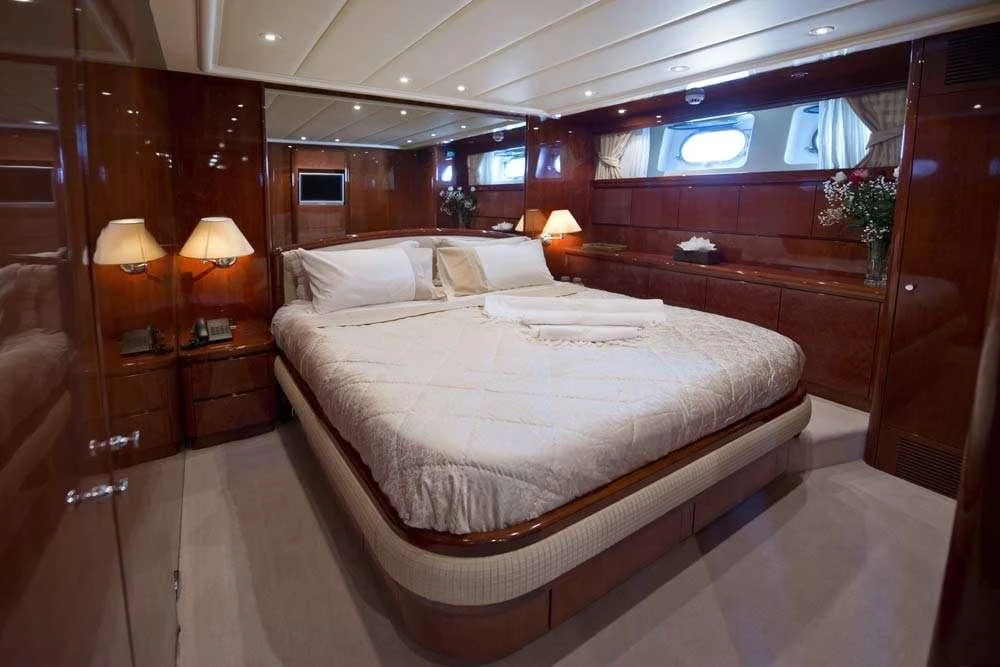 a room with a bed and a desk aboard FALCON ISLAND Yacht for Sale
