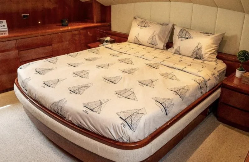 a bed with a white comforter aboard FALCON ISLAND Yacht for Sale