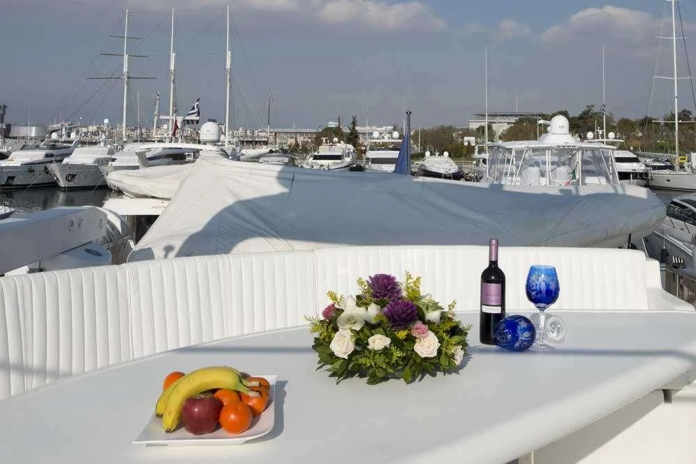 a table with wine bottles and flowers on it aboard FALCON ISLAND Yacht for Sale