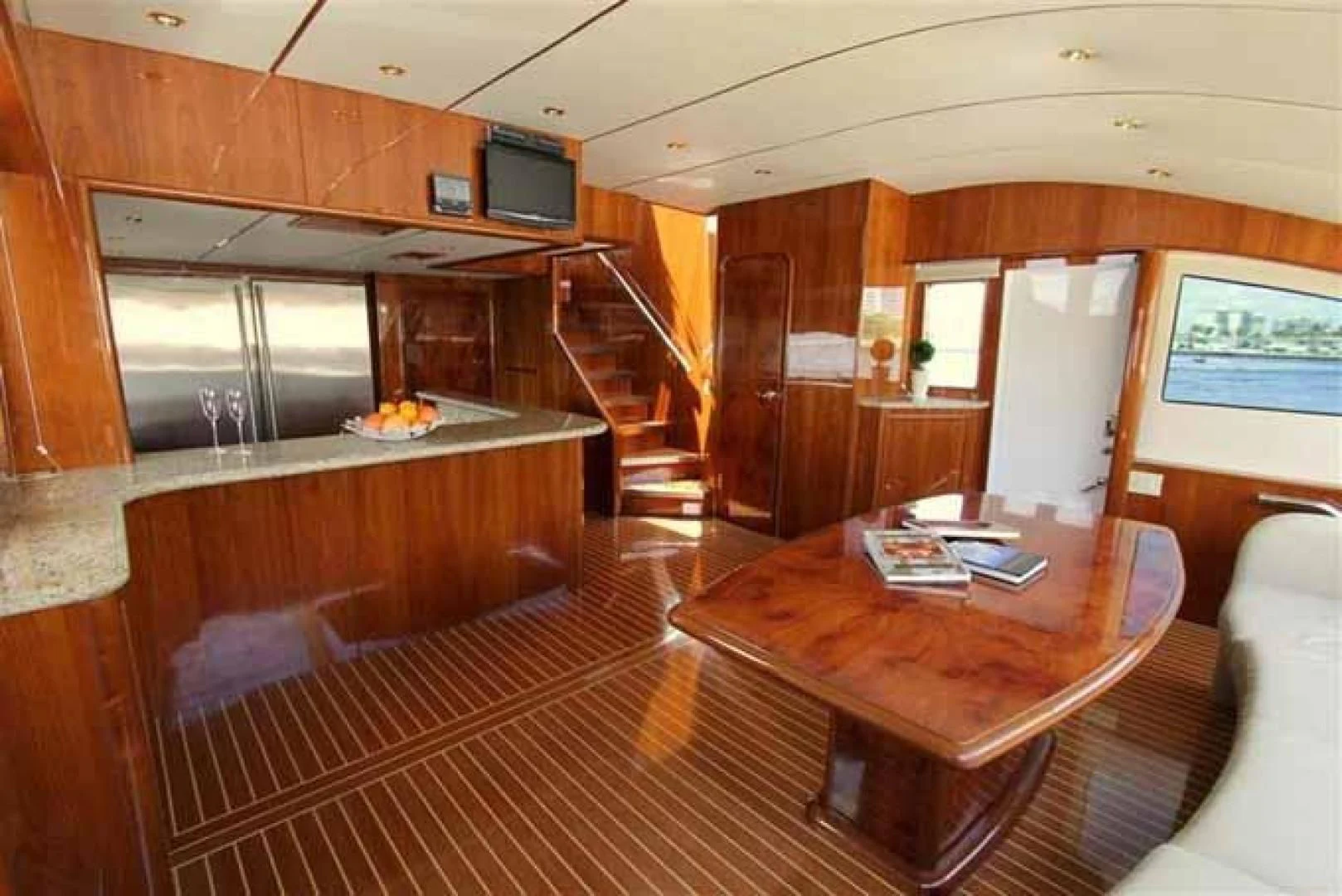 a room with a wood floor and a wood table and a tv aboard DOLCE VITA Yacht for Sale
