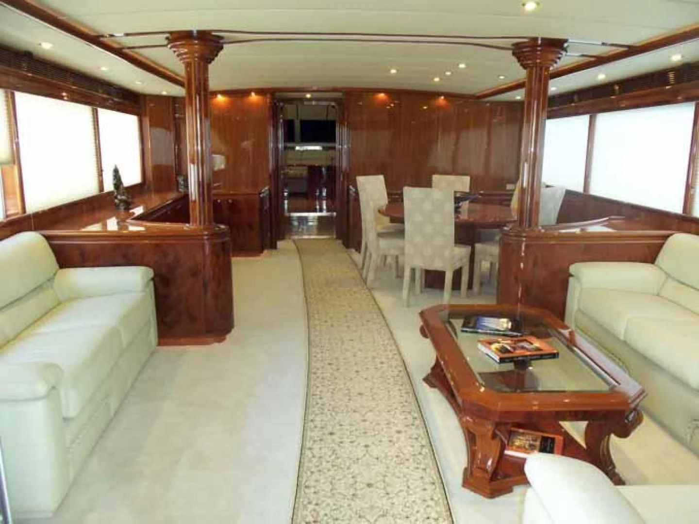 a living room with a table and chairs aboard DOLCE VITA Yacht for Sale