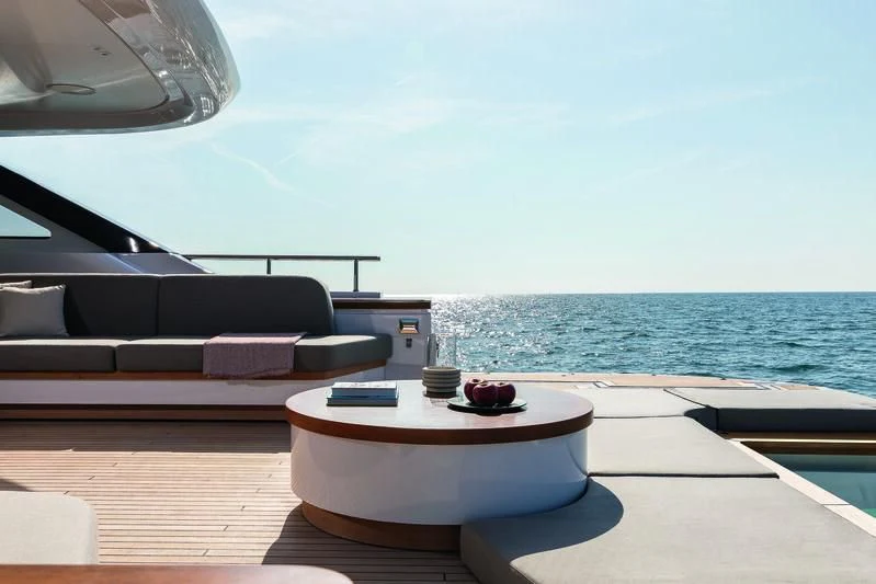 a room with a bed and a table with a view of the ocean aboard SEAESTA Yacht for Sale