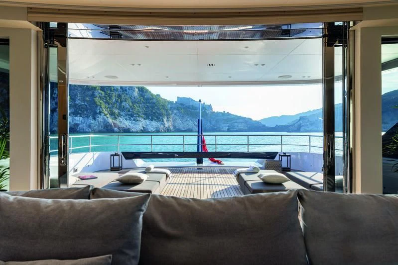 a living room with a view of the water and mountains aboard SEAESTA Yacht for Sale