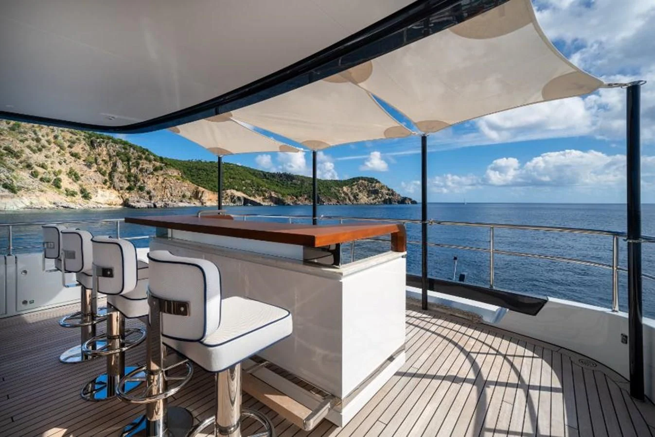 a table and chairs on a deck overlooking a large body of water aboard SEAESTA Yacht for Sale