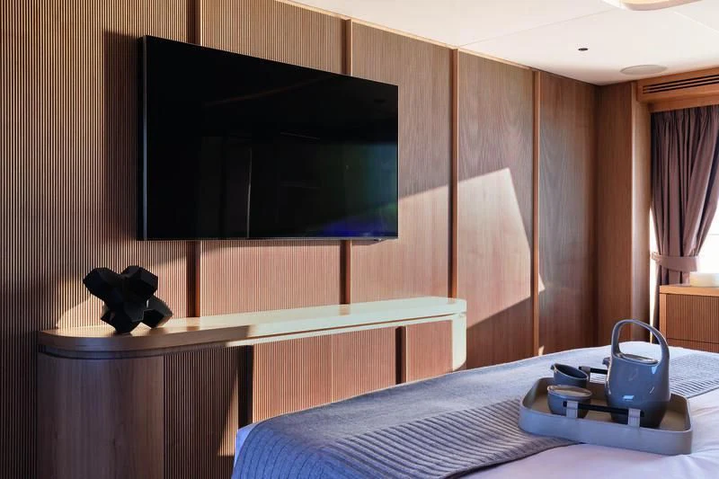 a bed with a television on the wall aboard SEAESTA Yacht for Sale