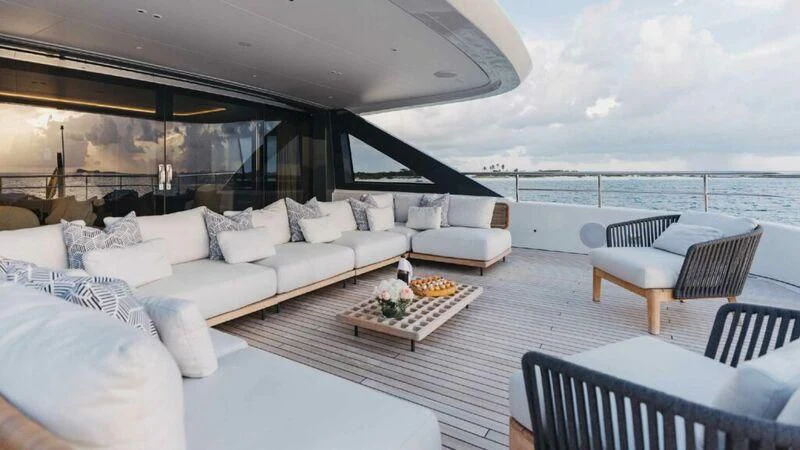 a living room with a large white sofa and a large ocean view aboard SEAESTA Yacht for Sale