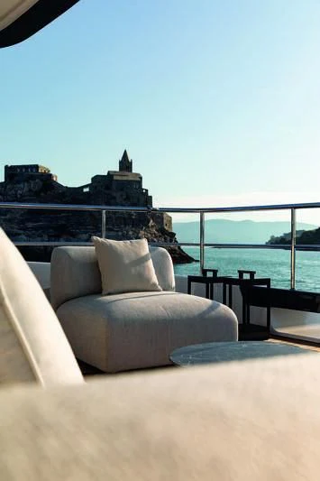 a couch on a patio by a body of water aboard SEAESTA Yacht for Sale