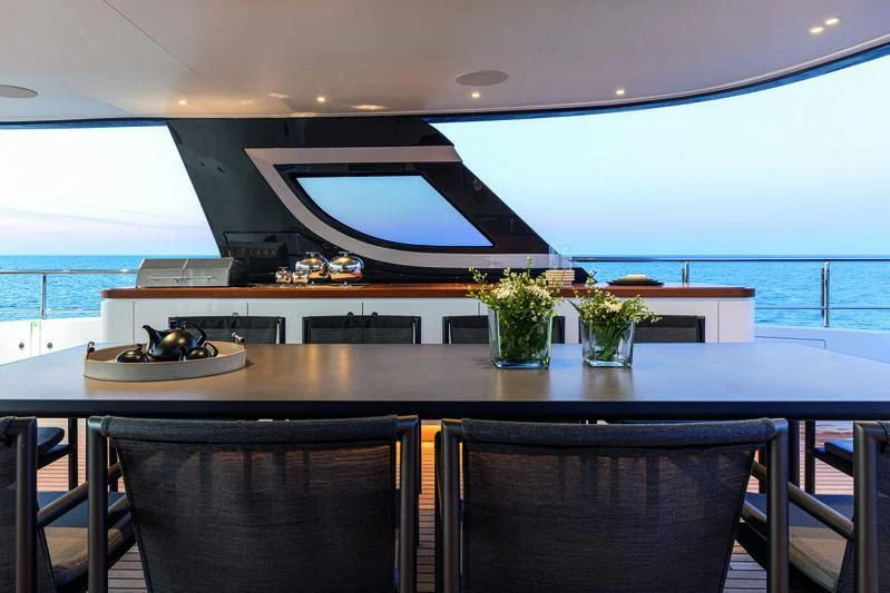 a large table with chairs and a plant on it aboard SEAESTA Yacht for Sale