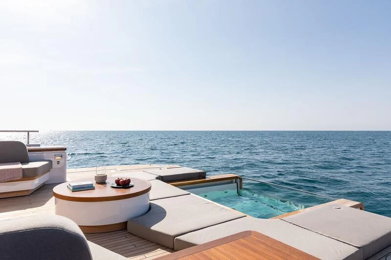 a pool with a table and chairs by the water aboard SEAESTA Yacht for Sale