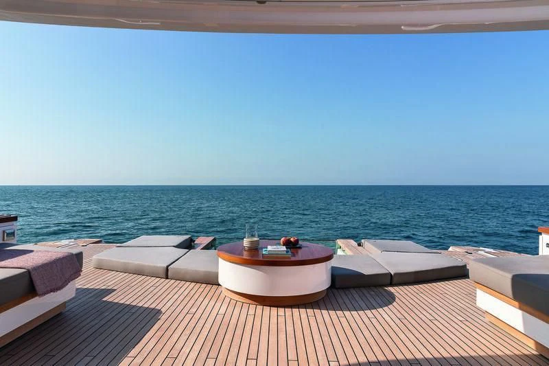 a table and chairs on a deck overlooking the ocean aboard SEAESTA Yacht for Sale