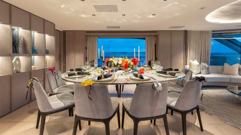 a large dining table with chairs and a large window aboard SEAESTA Yacht for Sale